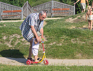 A grandfather teaches his granddaughter to use...